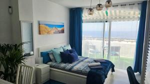 a bedroom with a bed and a large window at Ocean View Apartments in Adeje +30 photos