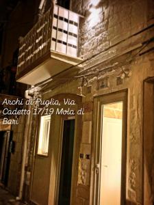 a sign on the side of a building with a door at Archi di Puglia in Mola di Bari