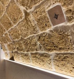 a stone wall with a sign on it at Archi di Puglia in Mola di Bari