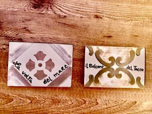 two cards sitting on a wooden table withigraphy at Archi di Puglia in Mola di Bari