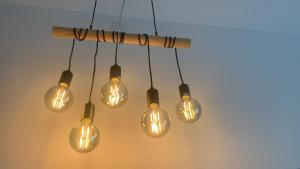 a group of light bulbs hanging from a wooden stick at Archi di Puglia in Mola di Bari