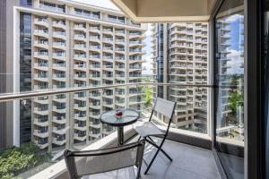 a balcony with a table and two chairs and large windows at Dominiks quite and Elegant Studio Ocean View Pool at Tambuli Resort High Floor in Maribago