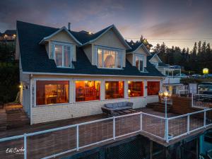 a house with a deck with a bench on it at La Maison Jaune in La Malbaie