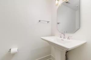 a white bathroom with a sink and a mirror at Short North Convention Garage Parking! in Columbus