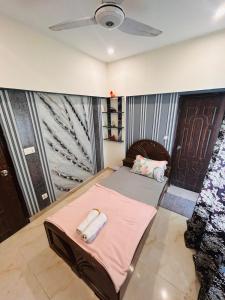 a room with a bed and a ceiling fan at Fare Home Apartment in Karachi