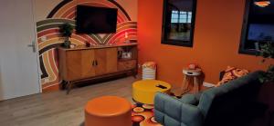 a living room with a couch and a tv at Colorama in Nozay
