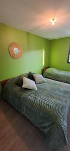two beds in a room with green walls at Colorama in Nozay