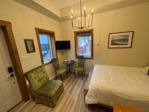 a bedroom with a bed and a chair and a table at Located in Downtown Whitehorse - Basekamp in Whitehorse