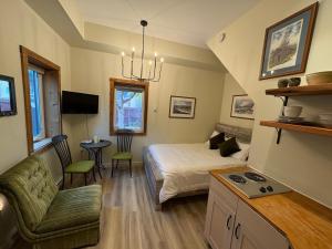 ein Schlafzimmer mit Bett und ein Wohnzimmer in der Unterkunft Located in Downtown Whitehorse - Basekamp in Whitehorse