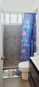 a bathroom with a toilet and a shower curtain at Apartamento Azul - Bayahíbe in Bayahibe