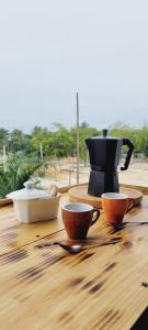 a wooden table with cups and utensils on it at Apartamento Azul - Bayahíbe in Bayahibe