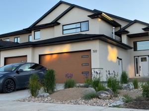 un coche aparcado delante de una casa en Cozy 2BR retreat in Rosewood, en Saskatoon