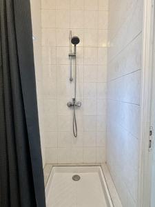 a shower with a shower head and a shower at Le Nid du Port in Étaples
