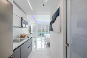 uma cozinha branca com uma pia e uma mesa em Condado Lagoon Villas-Lagoon View Studio em San Juan mais 8 fotografias