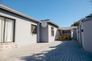 a white house with a brick driveway at Lovely and Peaceful 3 bedroom house in Cape Town