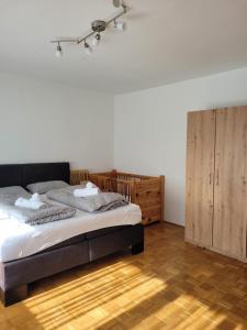 a bedroom with a bed and a wooden cabinet at Ferienwohnung Harpfing in Schnaitsee