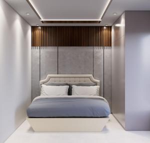 a bedroom with a white bed and a wall at Luxor in Hyderabad