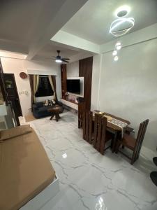 a living room with a table and chairs and a television at Amado Apartelle 1 Tagaytay in Kaybagal +2 photos