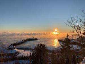 a sunset over a body of water with the sun setting at La Maison Jaune in La Malbaie