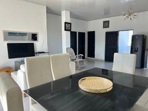 a dining room with a black table and white chairs at ARMANI in Puerto Colombia