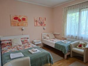 een kleine slaapkamer met 2 bedden en een stoel bij Lena apartment - Lena two bedroom apartment in Vecsés