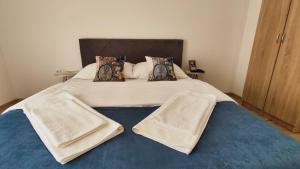 a large bed with white sheets and pillows on it at Apartmani TOKI in Mrkonjić Grad