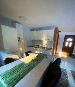 una cucina con un tavolo con sopra una composizione verde di Vikendica sa bazenom Cazin Pecigrad a Cazin