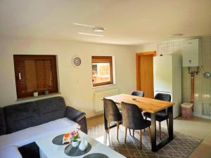 una cucina e un soggiorno con tavolo e divano di Vikendica sa bazenom Cazin Pecigrad a Cazin