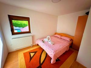 una piccola camera con letto rosa e finestra di Vikendica sa bazenom Cazin Pecigrad a Cazin Altre 4 foto