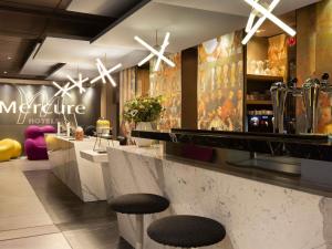 un bar dans un restaurant avec deux tabourets dans l'établissement Mercure Paris Alesia, à Paris