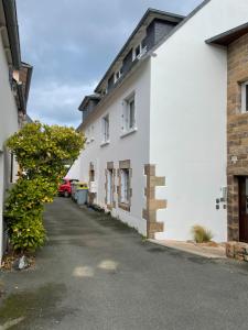 トレガステルにあるGrand T2 Côte de granit rose plages et commerces à proximitéの道路の前にある白い建物