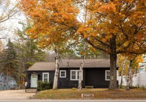 a black house with two trees in front of it at Centrally Located Cozy Modern Home in Bethel in Bethel