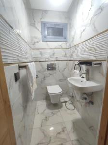 a white bathroom with a sink and a toilet at Ferme royale Bensliman in O Ben Slimane