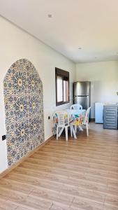 a kitchen with a table and a dining room at Ferme royale Bensliman in O Ben Slimane