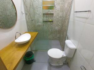 a bathroom with a toilet and a sink and a mirror at Casa Marajoara in Soure