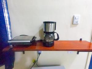 a coffee maker sitting on a wooden shelf with a blender at Casa Marajoara in Soure
