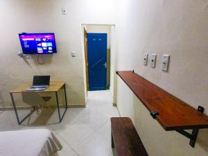 a room with a desk with a laptop and a blue door at Casa Marajoara in Soure +17 photos
