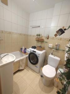a bathroom with a toilet and a sink and a washing machine at Kwatera garnizonowa in Zegrze Południowe