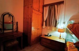 a bedroom with a bed and a desk and a mirror at AsteriA 3D House Inn in Pano Arodes