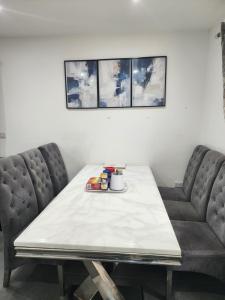 a dining room table with two chairs and a white table at Trinity Guest House in Highbridge