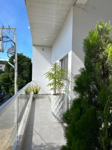 a white house with plants on a balcony at ALTAVITA apart completo a 100 m del mar in Puerto Colombia