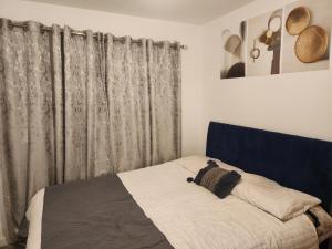 a bed with a blue headboard in a bedroom at Trinity Guest House in Highbridge