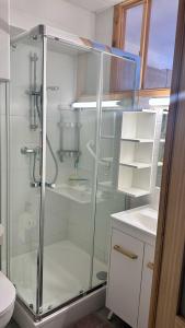 Un baño con ducha de cristal con inodoro. en Le Balcon du Soleil studio climatisé Wifi coin nuit lit douillet proche cure et étang, en Balaruc-les-Bains 5 fotos más