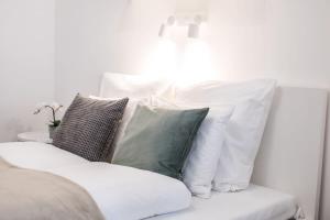 a pile of pillows sitting on a white couch at Extra Central NEW home with AC in Budapest +22 photos