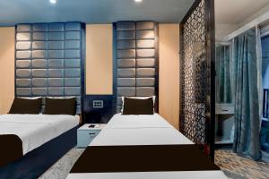 a bedroom with two beds and a window at Hotel O The KG Meridian in Ambāsamudram