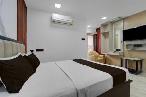 a bedroom with a large bed and a living room at Hotel O The KG Meridian in Ambāsamudram