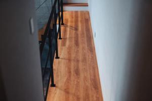 Un pasillo con suelo de madera y barandilla negra. en ウォーターハウス記念館, en Omihachiman