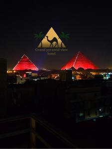 a group of red pyramids with the grand pyramid view hotel at Grand Pyramid View Hotel in Cairo