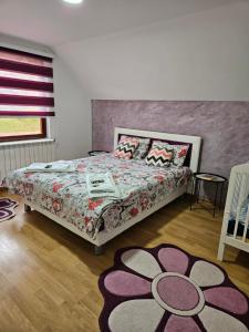 a bedroom with a large bed with a flower blanket at Apartmani NINA Zlatar in Nova Varoš