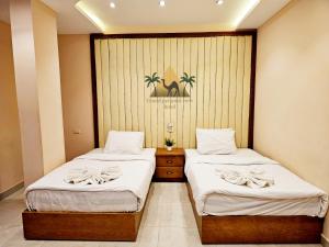 two beds in a hotel room withskirts at Grand Pyramid View Hotel in Cairo
